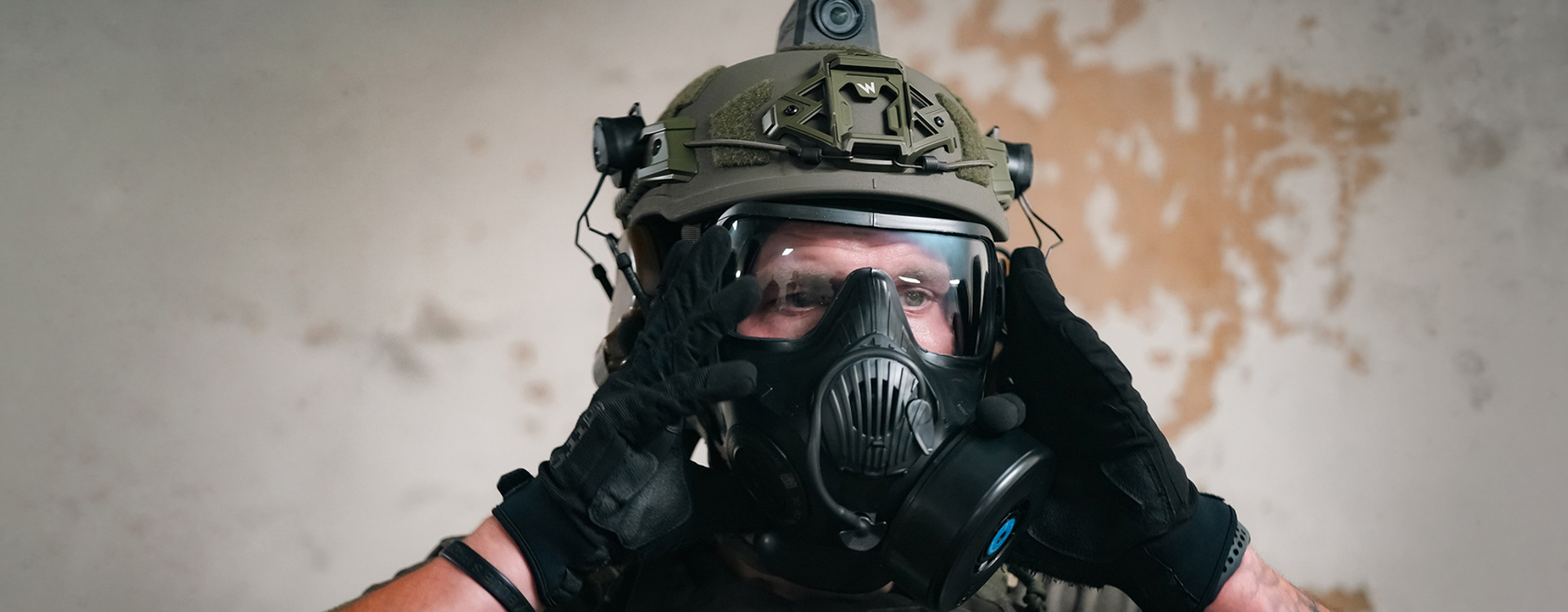 Man in gloves holding respirator on face