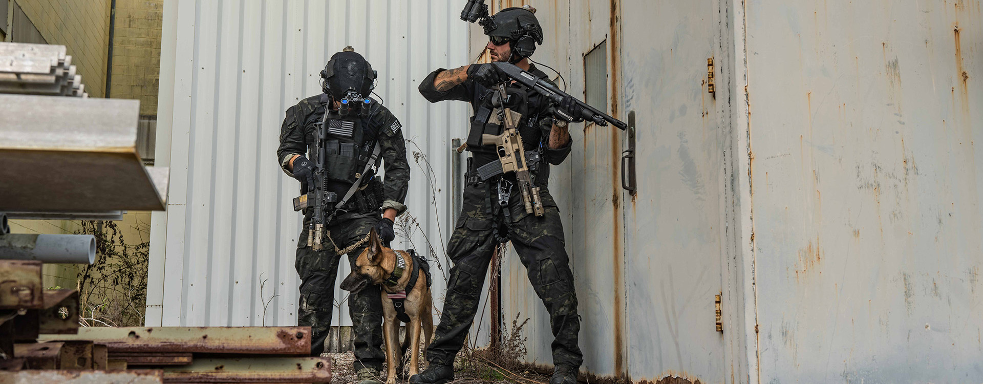 Two soldiers behind wall with dog and firearms