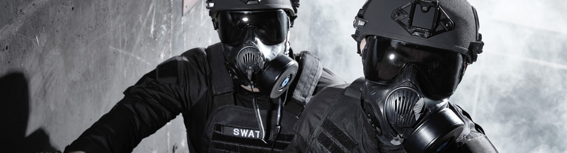 Two soldiers on staircase wearing ballistic helmets and respirators