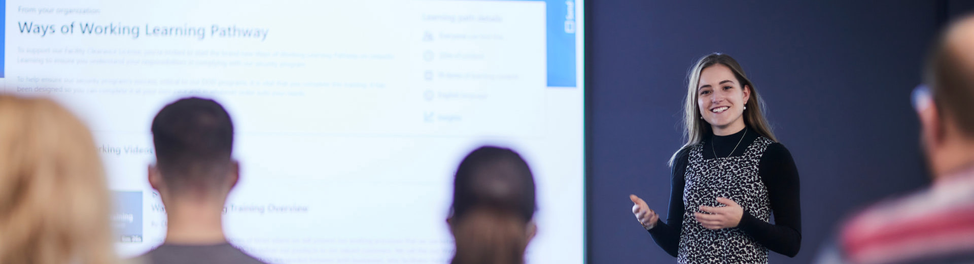 Employee presenting in front of a room of colleagues 