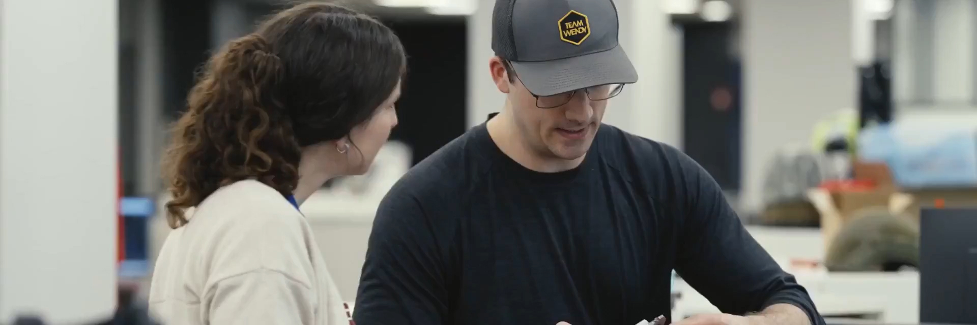 Male and female colleagues inspecting a Team Wendy helmet
