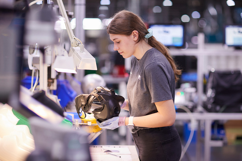 Female employee inspecting an Avon Protection 50 series respirator on a production line