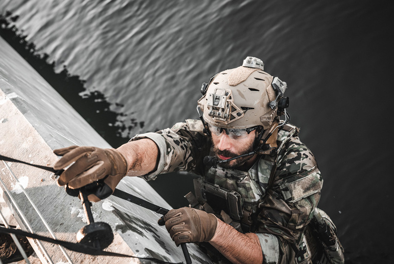 Man in camo and helmet abseiling
